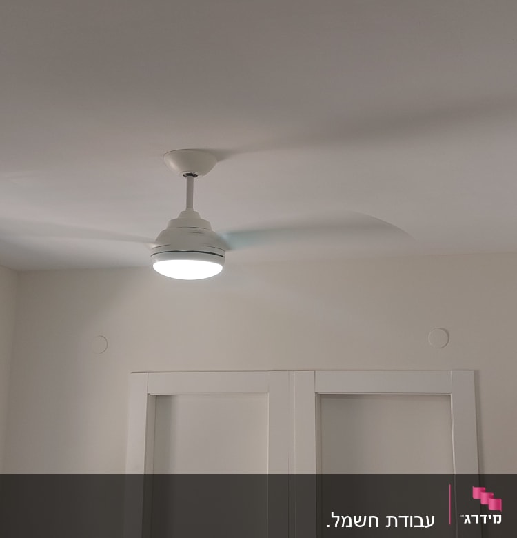 מאוורר תקרה עם תאורה מותקן בחדר